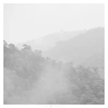 An image of foggy mountains receding into the distance in black and white.