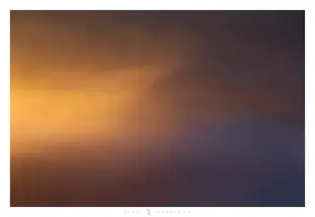 A photograph of fog being illuminated by the sun to a bright orange colour.